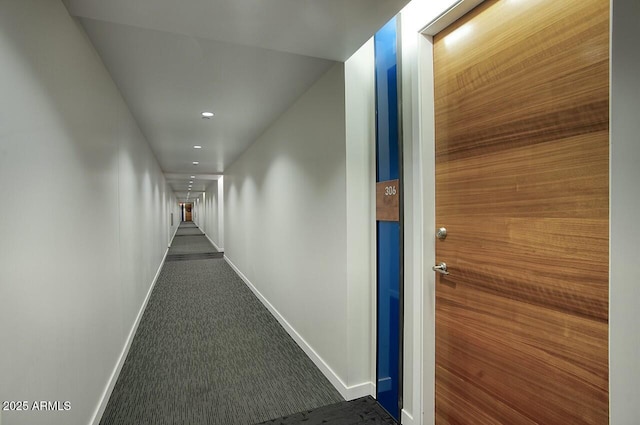 hall with dark colored carpet, recessed lighting, and baseboards