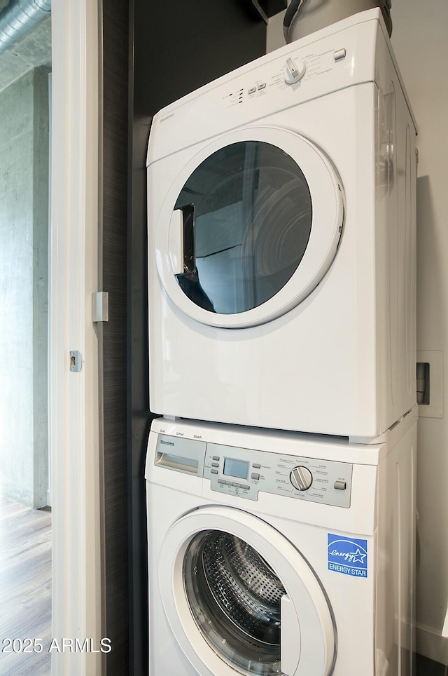 clothes washing area with stacked washer and clothes dryer