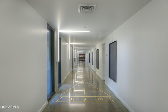 hallway with baseboards and visible vents