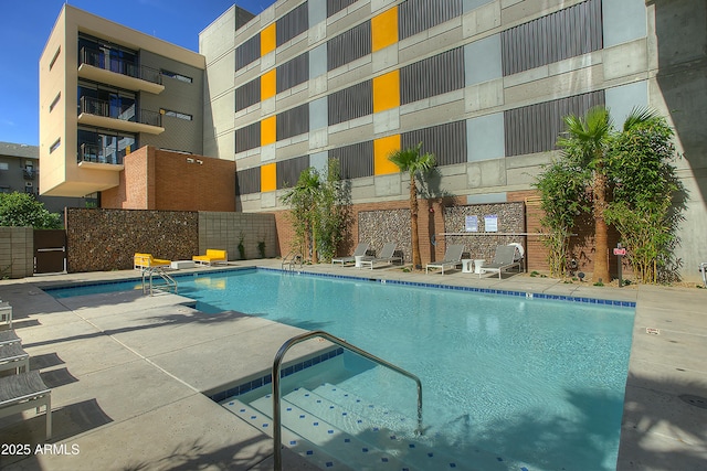 pool with fence and a patio