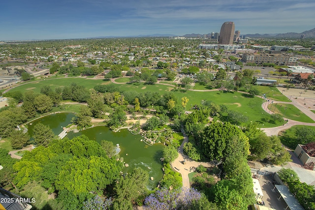 drone / aerial view with a water view, a city view, and golf course view