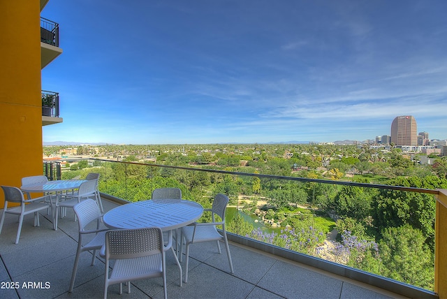 balcony with outdoor dining area and a city view