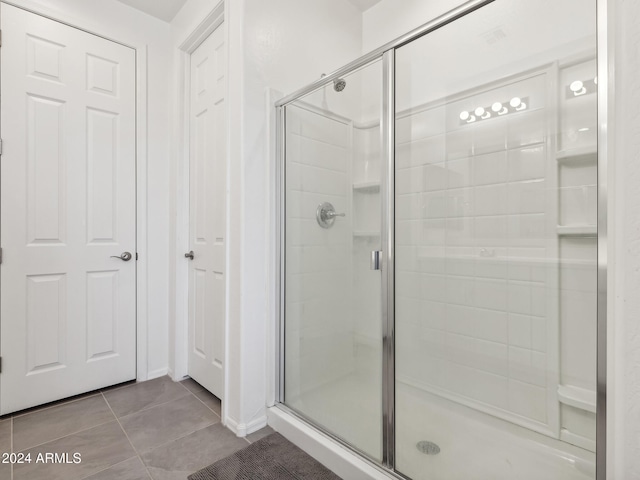 bathroom with tile patterned flooring and a shower with shower door