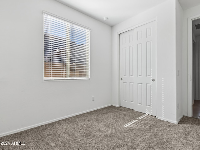 unfurnished bedroom with a closet and carpet floors