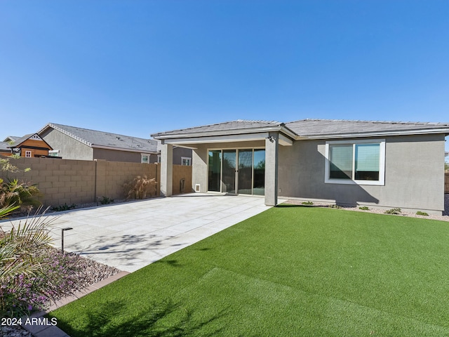 rear view of property with a lawn and a patio