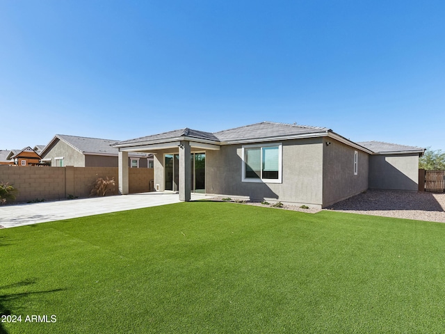 rear view of house featuring a lawn