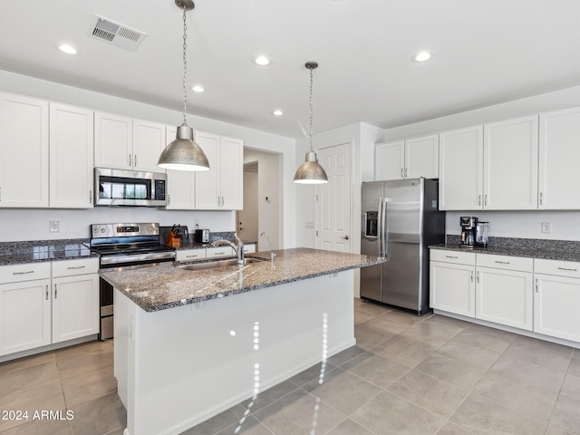 kitchen with stainless steel appliances, white cabinetry, sink, an island with sink, and pendant lighting