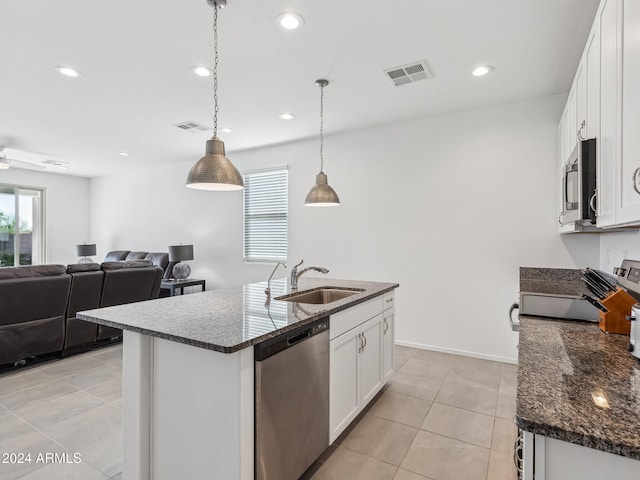 kitchen with a center island with sink, appliances with stainless steel finishes, hanging light fixtures, sink, and white cabinets