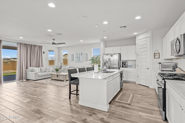 37954 N Greasewood Way, San Tan Valley, AZ 85140 - kitchen with appliances with stainless steel finishes, a sink, recessed lighting, a kitchen breakfast bar, and white cabinetry