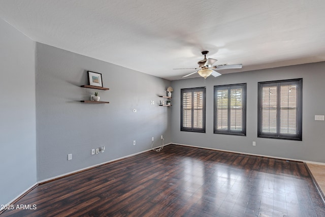 empty room with ceiling fan and dark hardwood / wood-style floors