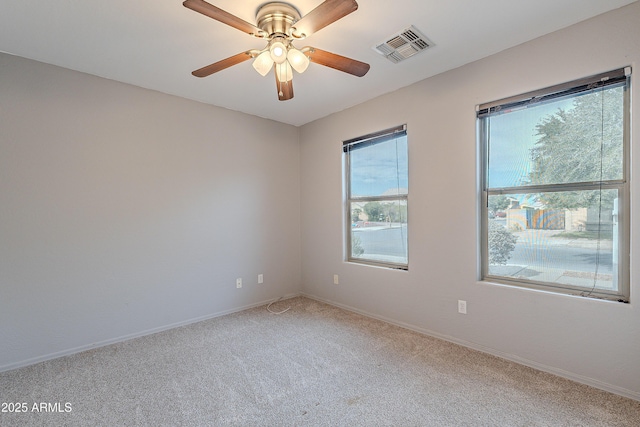 carpeted spare room featuring ceiling fan