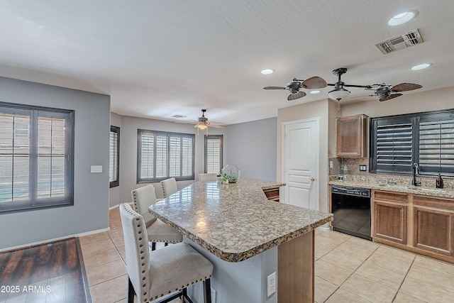 kitchen with dishwasher, a center island, sink, a kitchen bar, and decorative backsplash