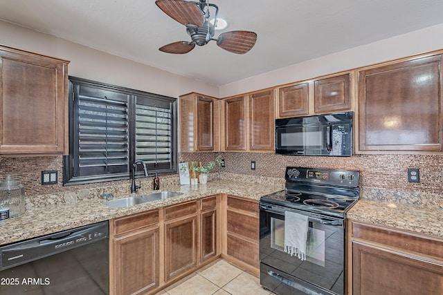 kitchen with light stone countertops, sink, decorative backsplash, light tile patterned floors, and black appliances