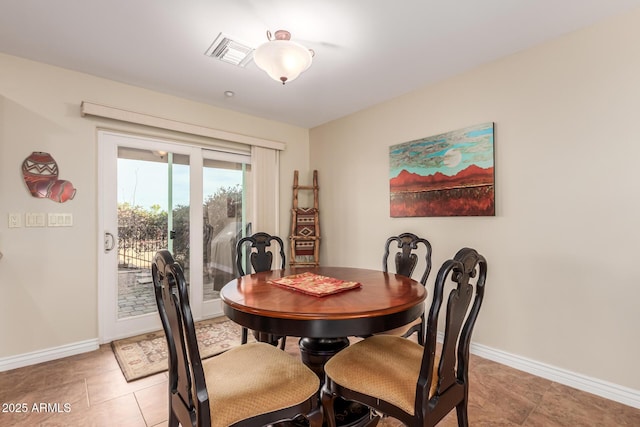 dining space featuring light tile patterned floors, visible vents, and baseboards