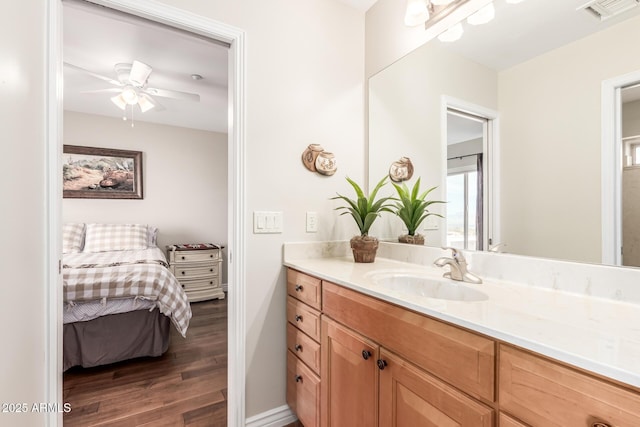 bathroom featuring visible vents, ceiling fan, vanity, ensuite bath, and wood finished floors