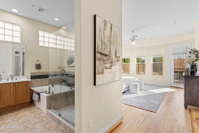 bathroom featuring hardwood / wood-style floors, vanity, ceiling fan, and a healthy amount of sunlight