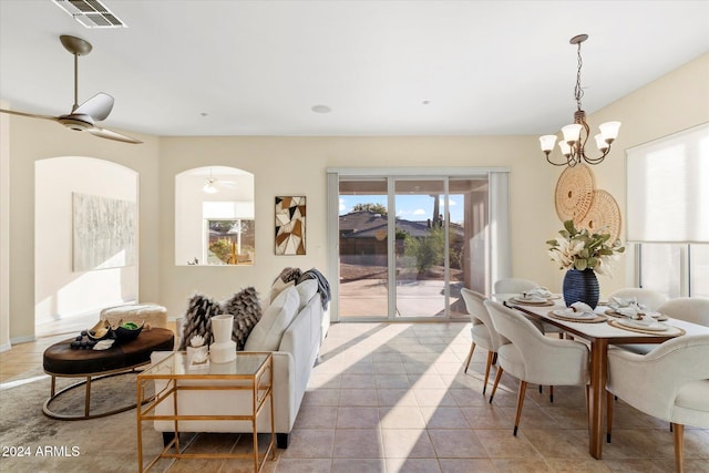 tiled dining area with ceiling fan with notable chandelier