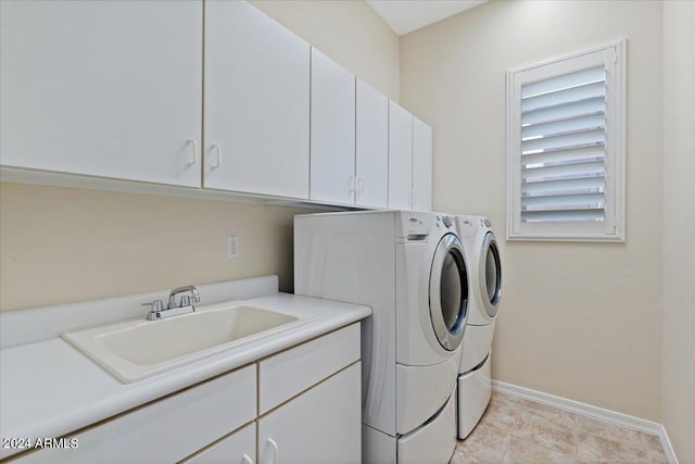 laundry area featuring washing machine and clothes dryer, sink, and cabinets