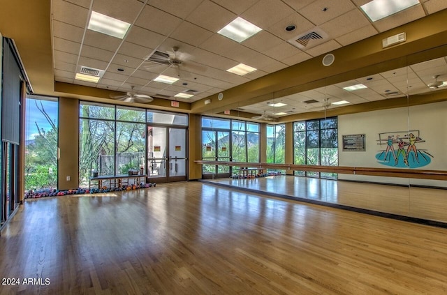 interior space with wood-type flooring, a drop ceiling, and ceiling fan