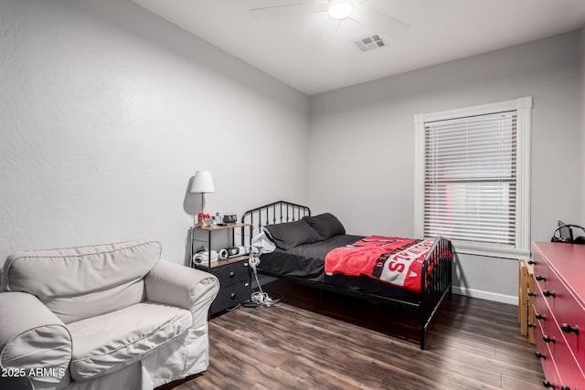 bedroom with a ceiling fan, visible vents, baseboards, and wood finished floors