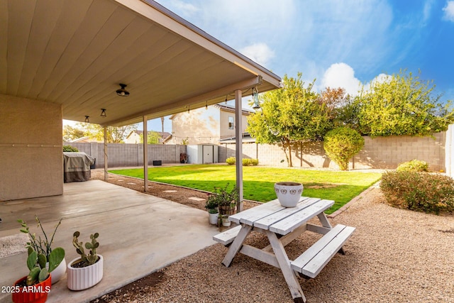 view of patio / terrace with an outbuilding, a shed, and a fenced backyard