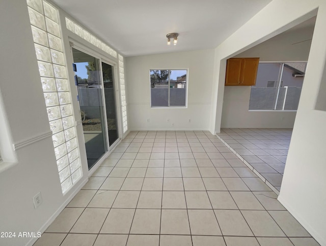 tiled spare room featuring lofted ceiling