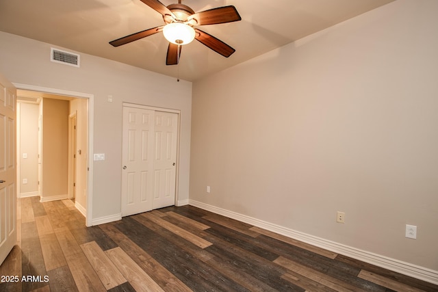 unfurnished bedroom with dark hardwood / wood-style flooring, a closet, and ceiling fan