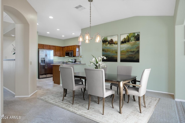 dining room featuring lofted ceiling, light colored carpet, and a notable chandelier