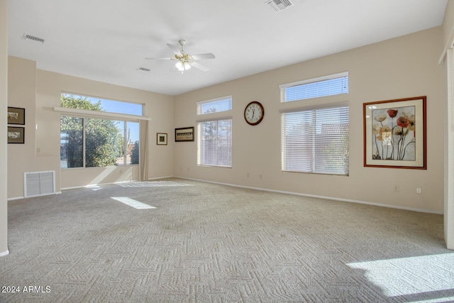 carpeted spare room featuring ceiling fan