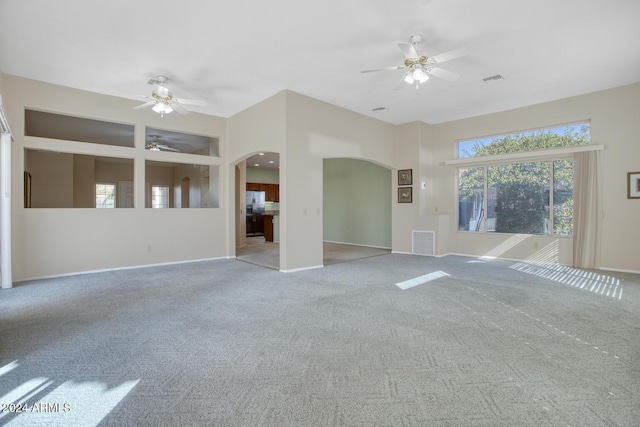 spare room with ceiling fan and light colored carpet