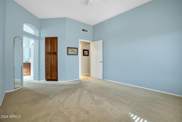 unfurnished bedroom featuring light colored carpet and a high ceiling