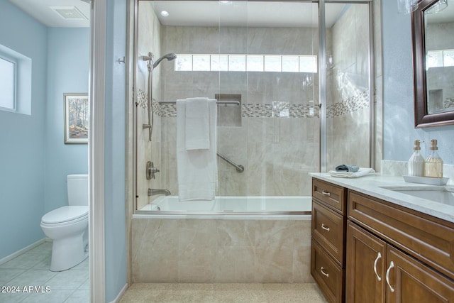 full bathroom with vanity, a healthy amount of sunlight, tiled shower / bath combo, and toilet