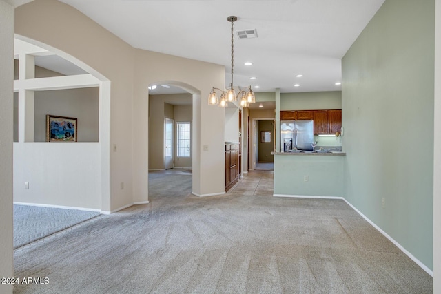 interior space with light colored carpet and an inviting chandelier