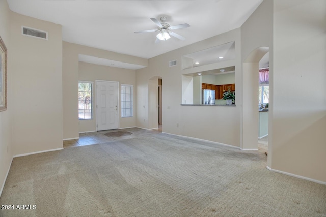 carpeted spare room with ceiling fan