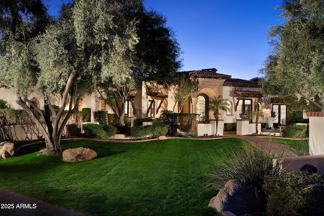 view of front of property featuring a front yard and french doors