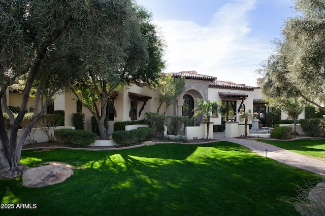 mediterranean / spanish house featuring a front yard