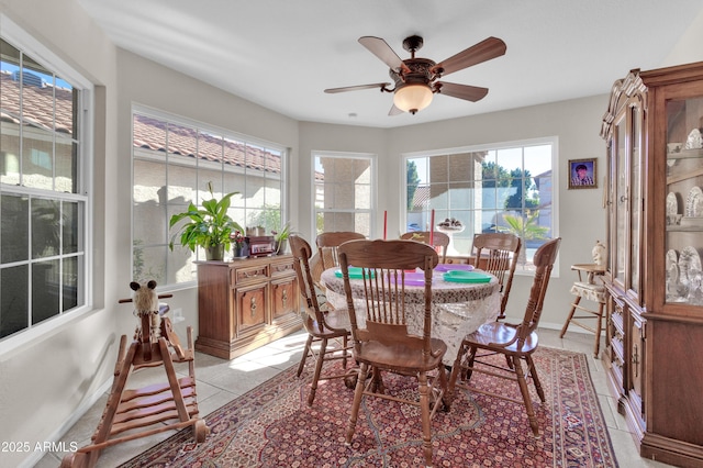 dining space featuring ceiling fan and light tile patterned floors