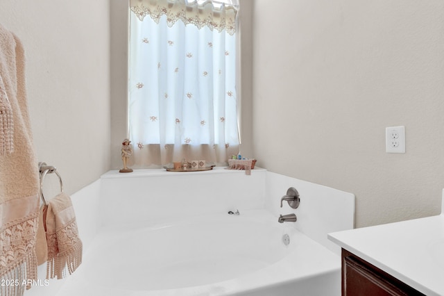 bathroom with vanity and a bath