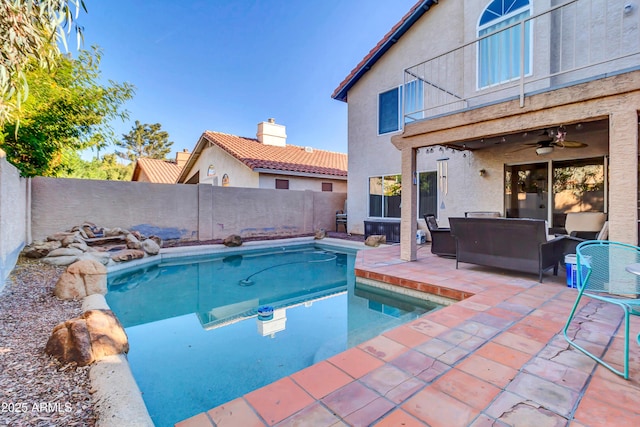 view of pool with an outdoor living space, ceiling fan, and a patio area