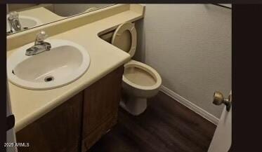 4601 N 102nd Ave Unit 2202, Phoenix, AZ 85037 - bathroom with baseboards, vanity, toilet, and wood finished floors