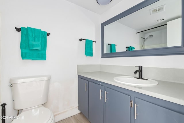 bathroom with a shower, toilet, and vanity