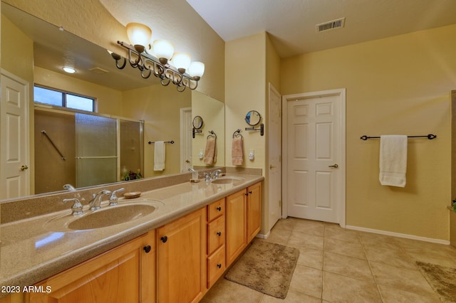 bathroom with tile floors, a shower with door, large vanity, and double sink