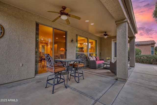 patio terrace at dusk featuring ceiling fan