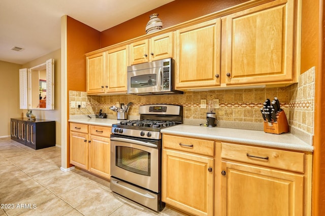 kitchen featuring backsplash, light tile flooring, and stainless steel appliances