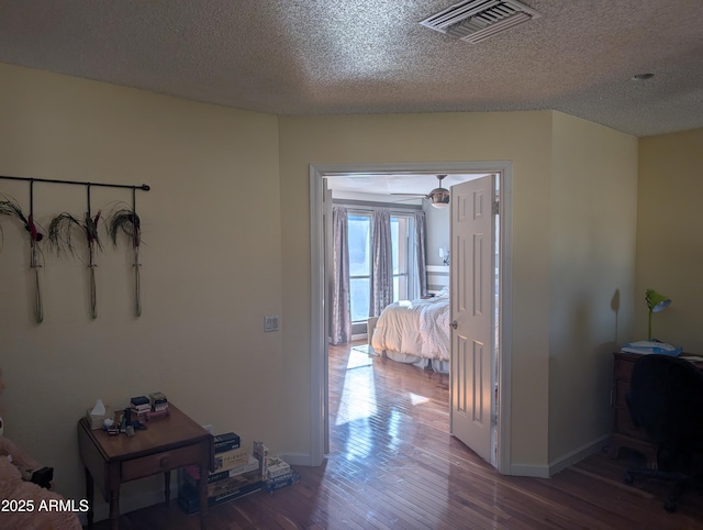 corridor featuring hardwood / wood-style flooring and a textured ceiling