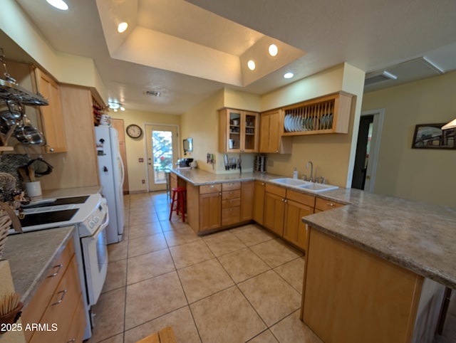 kitchen with sink, light brown cabinets, a tray ceiling, kitchen peninsula, and white appliances