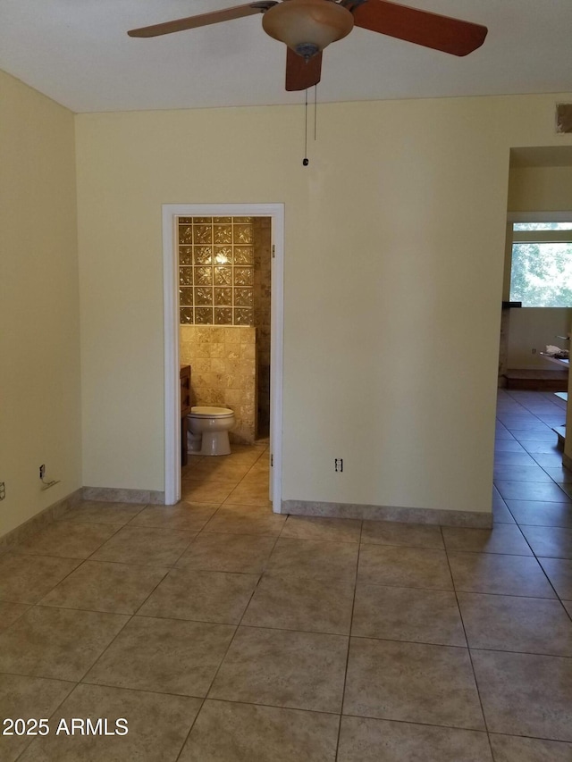 tiled spare room featuring ceiling fan