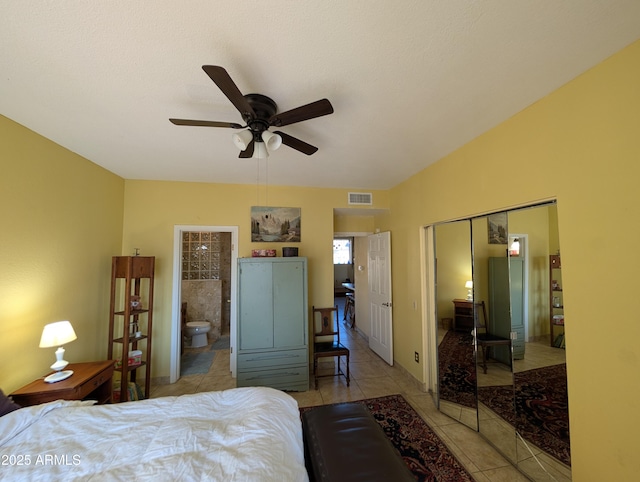 bedroom featuring connected bathroom, a closet, ceiling fan, and light tile patterned flooring