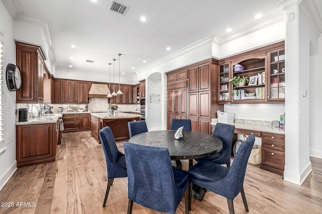 dining area featuring light wood finished floors, baseboards, and visible vents