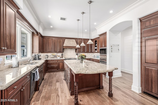 kitchen featuring custom range hood, a kitchen breakfast bar, a kitchen island, visible vents, and decorative backsplash